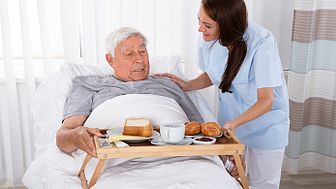 Patient får frukost serverad i sängen.
