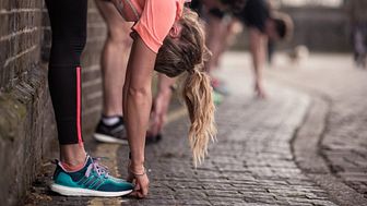 Woman in running gear stretching