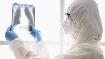Bild på person som tittar på en röntgenplåt. Källa: Colourbox