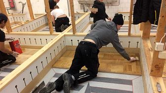 I de individuella övningsbåsen  på Stockholms byggtekniska gymnasium tränar eleverna olika moment som ingår i golvläggaryrket.