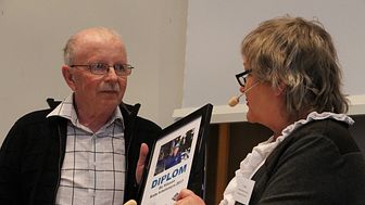 Bo Nilsson tar emot priset "Årets arbetsmyra" av Arbetets museums vänförenings ordförande Li Teske.