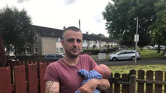 Stroke survivor Connor Shevlin at his home in Belfast holding his four week old son baby Aidan
