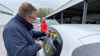 Mats Linderholm, förvaltningschef teknisk serviceförvaltning, och Emilie Ekander, enhetschef kommunikation, försåg tillsammans de första av kommunens bilar med dekalerna som ska påminna om att hålla avstånd.
