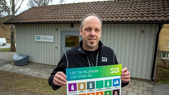 Anders Johansson byter ut avfallssymboler i Svenska Bostäders miljöstuga i Vällingby