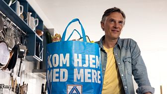 En farvestrålende bærepose med Aldis nye slogan ’Kom hjem med mere’ er det gennemgående visuelle element i Aldis nye reklameunivers.