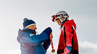 Skischulleiter Noldi Heinz überreicht einem Skischüler eine Medaille, Arosa Skischule, Arosa-Lenzeheide (Graubünden)