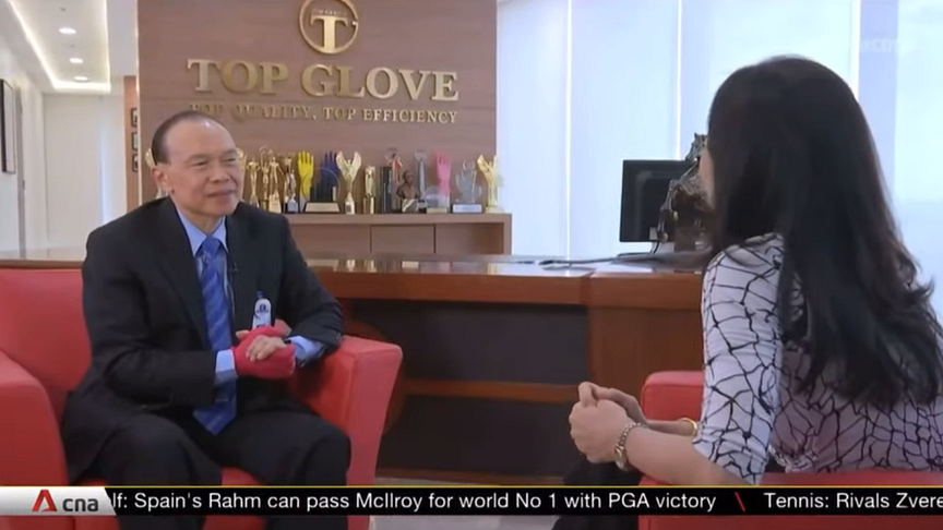 Dr Lim Wee Chai gives an interview with his product shown prominently on his right hand