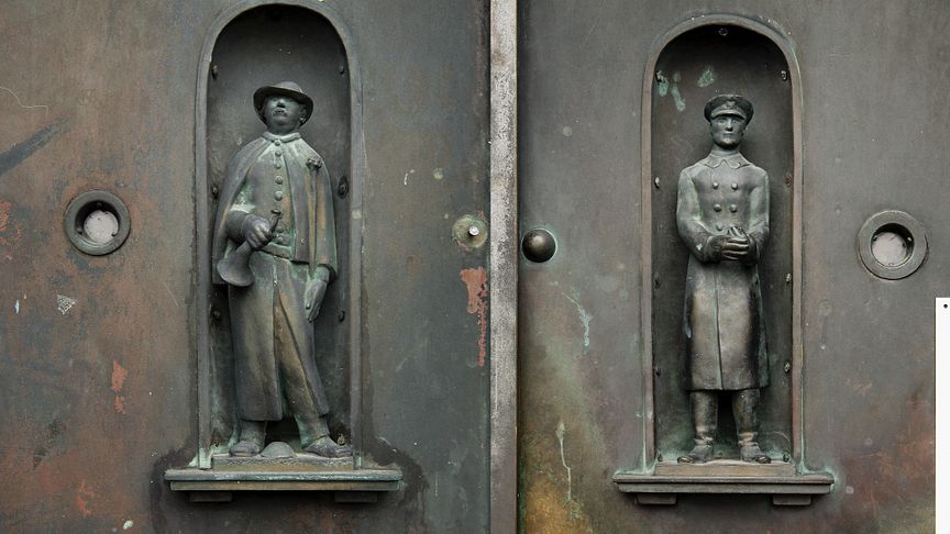 De två försvunna figurerna är skapade av skulptören Anders Olson. Väktaren, till vänster i bild,  bar vid försvinnandet kapprock, mössa och träskor. Till höger i bild Poliskonstapeln iförd uniform m/26.