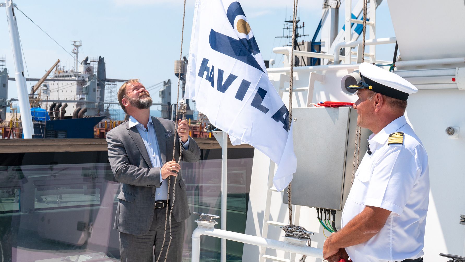 CEO Bent Martini raises the shipping company's flag on board Havila Polaris. To the right: Captain Kurt Harald Nærbø. (Photo: Martin Giskegjerde/Oclin) (Image at LateCruiseNews.com - August 2023)