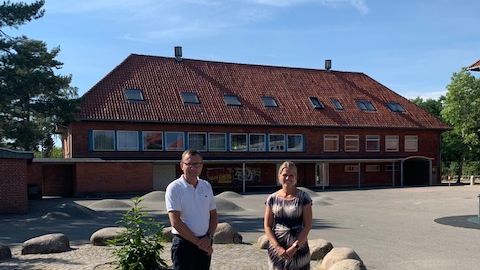 Formand for Børne- og Skoleudvalget Daniel E. Hansen (V) og skoleleder Annika Palmelund foran én af de to skolegårde, der skal renoveres.