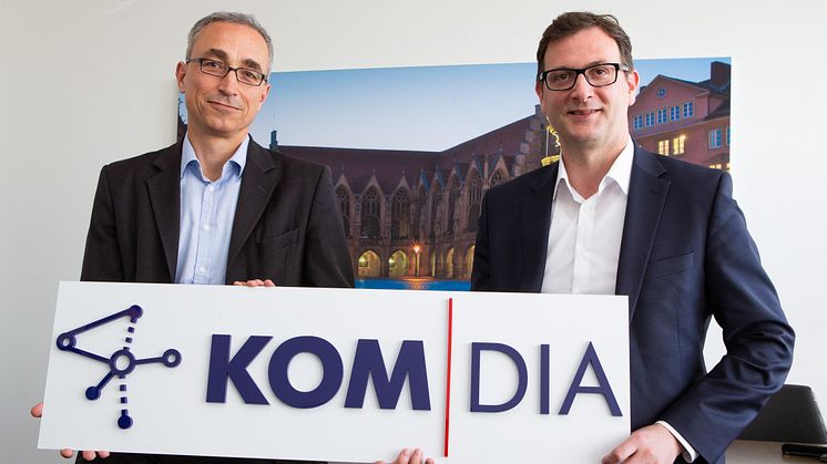 Dr. Volker Lang und Julien Mouniert mit der neuen Wort-Bild-Marke KOM│DIA