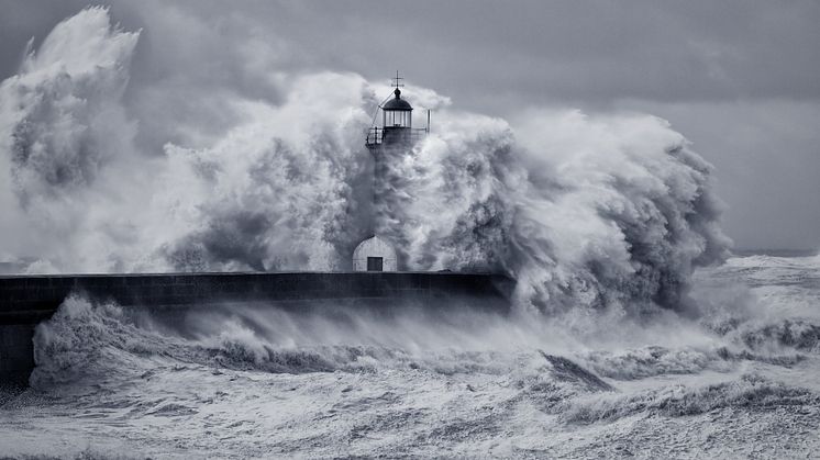 Stock massive wave hitting a lighthouse on a pier