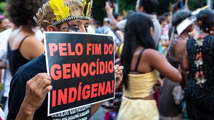 En demonstrant holder et skilt pålydende "for afslutningen på folkemordet imod oprindelige folk" til en demonstration i Sao Paulo i Brasilien - et land, hvor oprindelige folk tvangsfjernes og myrdes, så landbruget kan udvidde sin produktion