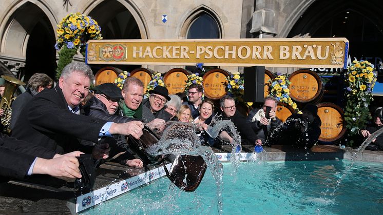Dieter Reiter, Ernst Wolowicz und Andreas Steinfatt waschen die Geldbeutel am Fischbrunnen am Marienplatz