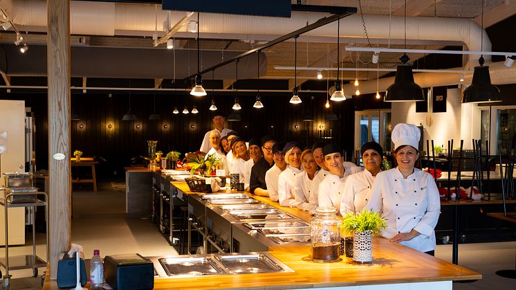 Personalen på Åbyskolans kök framför den nya serveringslinjen i ek.