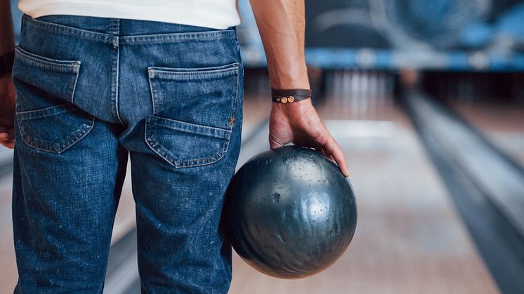 rear-particle-view-man-casual-clothes-playing-bowling-club