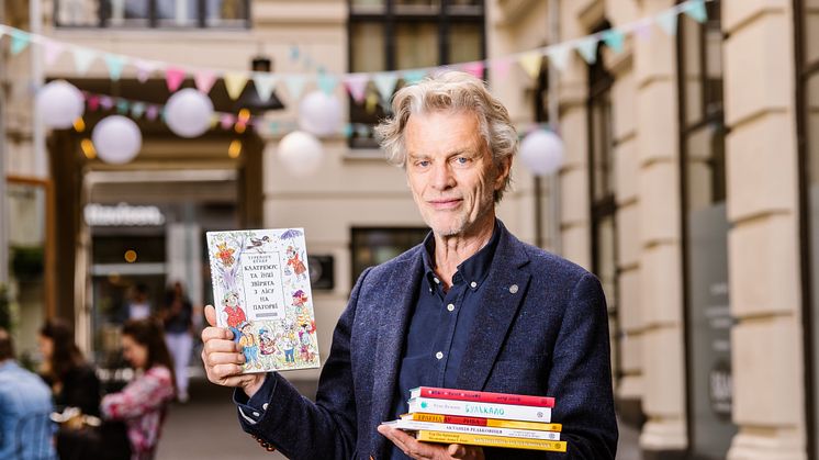 Tom Harald Jenssen, administrerende direktør i Cappelen Damm, viser frem de seks bøkene i det ukrainske barnebokbiblioteket som forlaget nå sender ut gratis til ukrainske barn i Norge