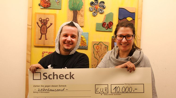 André Karsupke und Ulrike Herkner präsentieren stolz den Spendenscheck im Kinderhospiz Bärenherz
