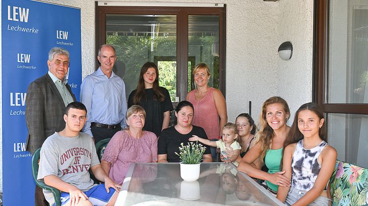 Buchloes zweiter Bürgermeister Herbert Barthelmes und LEW-Vorstand Dietrich Gemmel begrüßen die ukrainischen Familien in ihrem neuen Zuhause (LEW/Thorsten Franzisi)