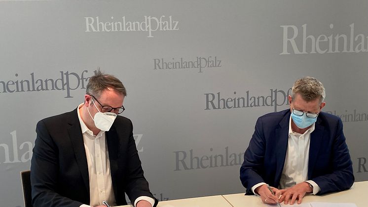 Alexander Schweitzer, Digitalminister von Rheinland-Pfalz und Thorsten Dirks, CEO von Deutsche Glasfaser unterschreiben die Absichtserklärung