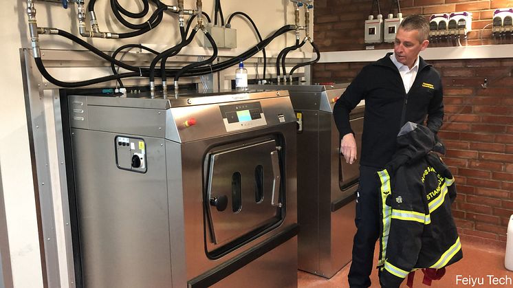 Räddningschef Andreas Bengtsson vid tvättmaskinen som kan tvätta larmställ utan kemikalier.