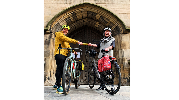 Northumbria University PhD researcher Shaun Cutler hands over the Cathedrals Cycle Route relay baton to The Revd Canon Clare MacLaren outside Newcastle Cathedral.