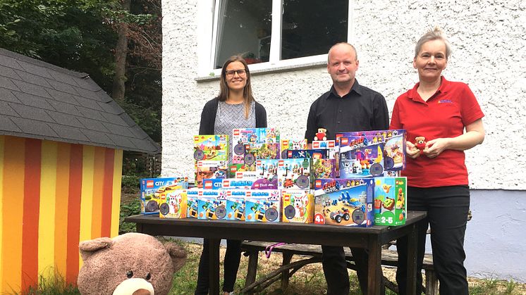 Luise Kuepper (Bärenherz), Frank Berthmann und Kerstin Walker (LBRICK e.V.) präsentieren stolz die neuen Logo-Spielsachen für Bärenherz