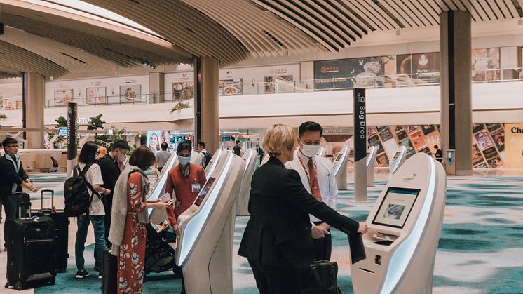 1. SIA passengers checking in for their flight at the automated check-in kiosks.