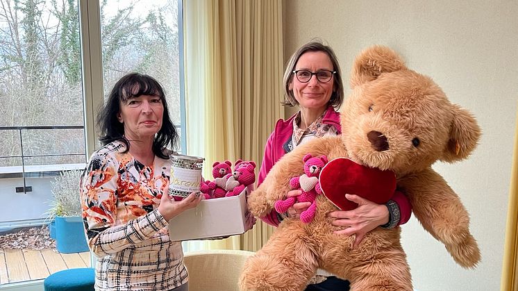 Frau Schilling überreicht Anke Voigt eine volle Spendendose und pinkfarbene Herz-Bärchen