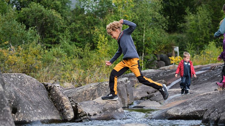 Boy jumping over a stream. Photo:  Matias Fosso