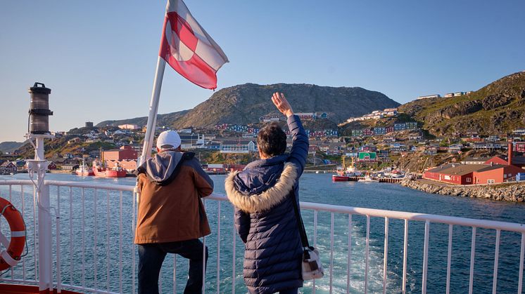 Passengers wave flag Sarfaq Ittuk. Photo - Lisa Germany Visit Greenland