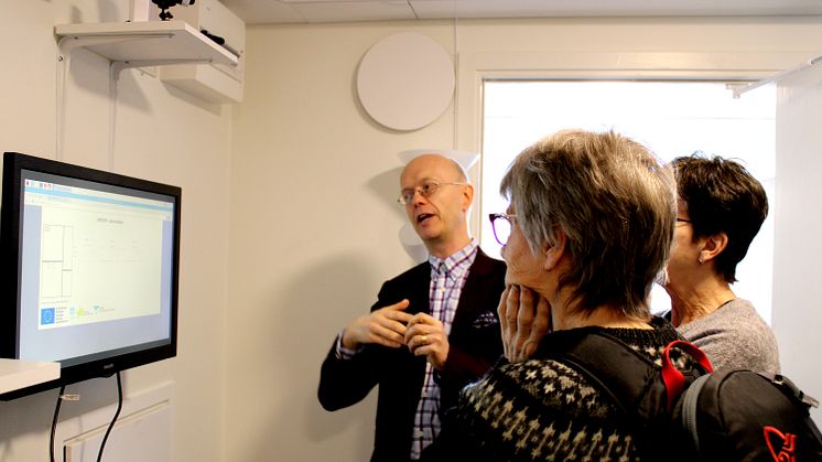 Jonas Melin visar tekniken i testlägenheten för besökare.
