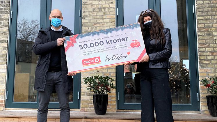 Marketing- og kommunikationschef fra Circle K Danmark Morten Christensen overrækker juledonationen på 50.000 kr. til leder af værestedet på Hellebro Dorte Glad.