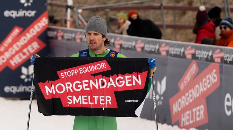 Skiløper Emil Johansson Kringstad holder opp et banner med teksten «Stopp Equinor! Morgendagen smelter». Foto: Marthe Haarstad/Greenpeace Norge