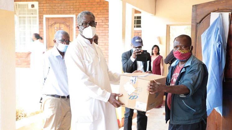 Senga Nsese, servicetekniker, lämnar över tester från Sverige till Panzisjukhusets chefsläkare Denis Mukwege. Foto: Läkarmissionen