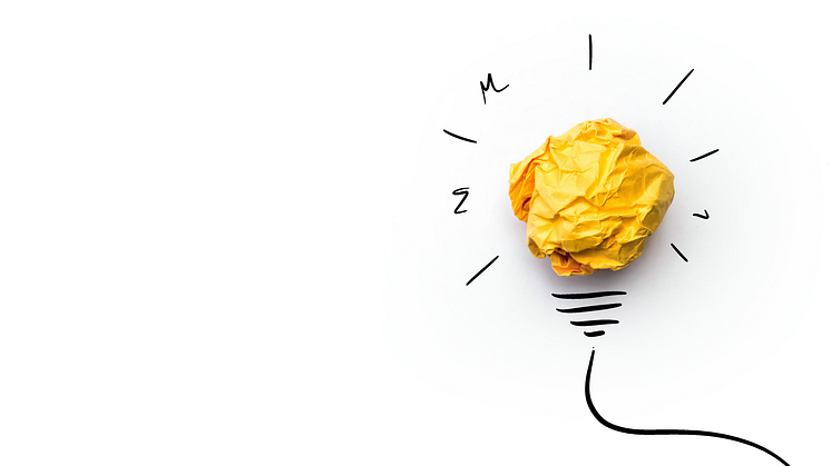 A yellow scrunched ball of paper forms the centre of an illustrated lightbulb against a white background. Royalty-free stock photo ID: 422864347.