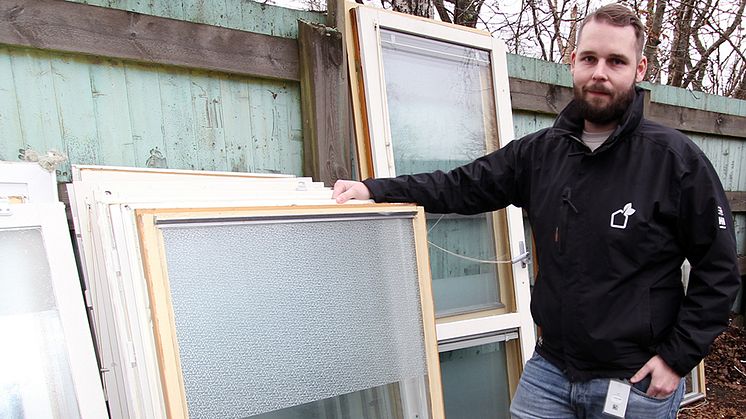 Projektledare Christoffer Karlsson visar några av de fönster som ska återvinnas.