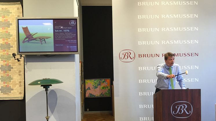 Frederik Bruun Rasmussen sælger Wegners "Delfinstol" for 320.000 kr. PH-lampen ses i forgrunden.