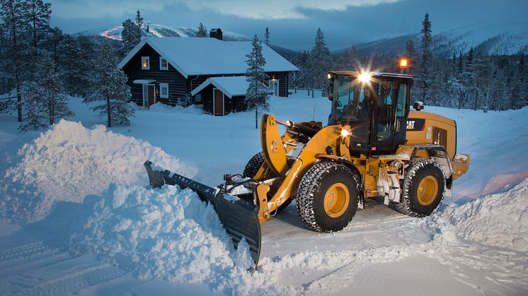 Cat 930 plogar snö i vintermiljö.