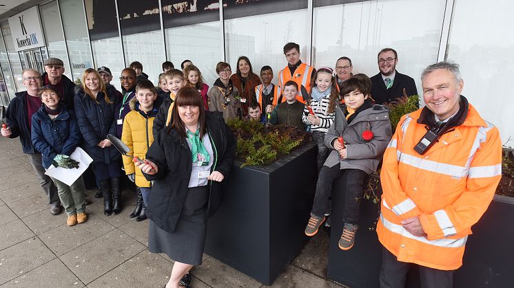Railway staff, volunteers and local children gather at Milton Keynes station to fill new planters outside the station entrance