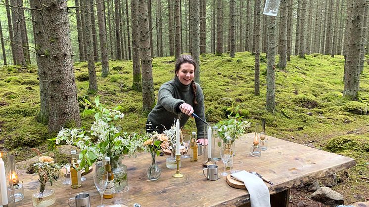 Emma Ekaremål, VD på Asa Herrgård i Småland, dukar bordet i skogen för mat och dryckestillredning.