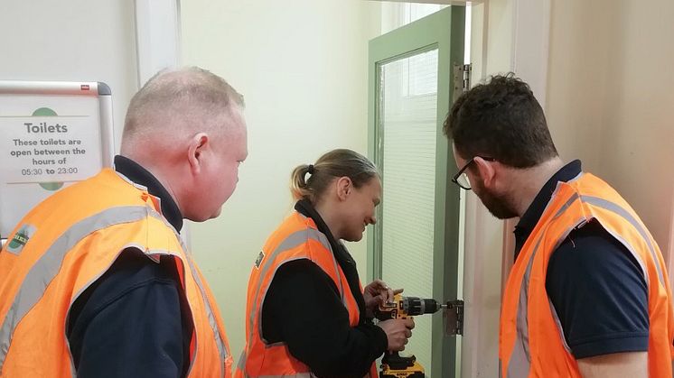 Natalie Parker repairing a toilet door at Worthing station in her first week