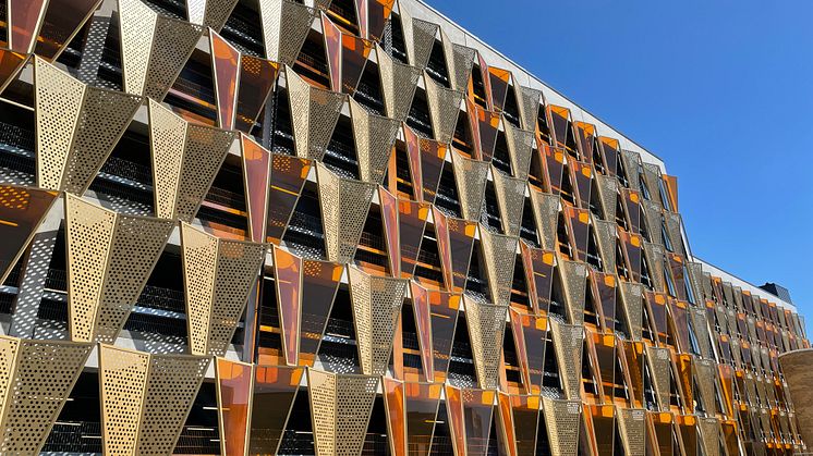 Den fjärilslika fasaden in mot Medicon Village fångar blicken på långt håll i oranget plexiglas och guldfärgad aluminium. 