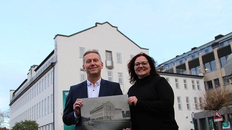 Jürgen Noch und Annemarie Marx zeigen ein Foto mit der denkmalgeschützten Fassade von 1955