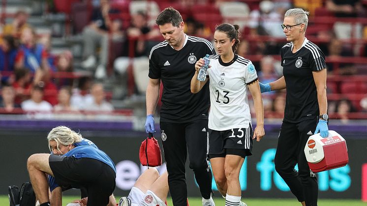 Osteopathin Birgit Halsband (r.) begleitet Nationalspielerin Sara Däbritz (M.) mit Mannschaftsarzt Tobias Schmenn (l.) beim EM-Spiel gegen Dänemark. Foto: DFB