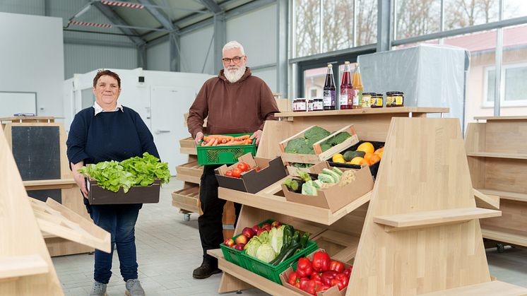 Sabine Schäfer, Beschäftigte der Hephata-Gärtnerei, und Gärtnereileiter Klaus Lewinsohn bestücken ein Regal im neuen Laden mit Gemüse. 