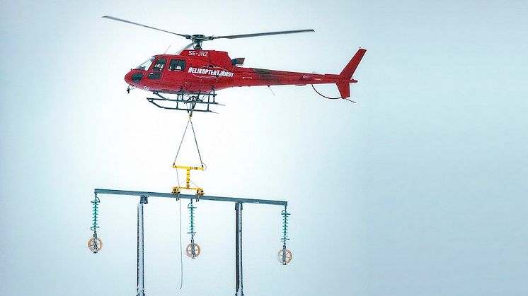 Med stor precision sätter helikopterpiloten ned regeln på stolptopparna.