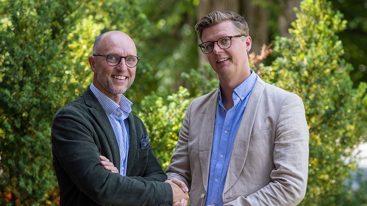 Mikael Sjölund, vd Coreco och Peter Björk, affärsområdesansvarig för Byggfakta Tender, tar i hand för ett nytt samarbete mellan bolagen.