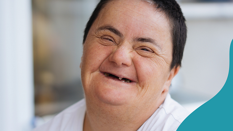 äldre kvinna med Downs syndrom ler