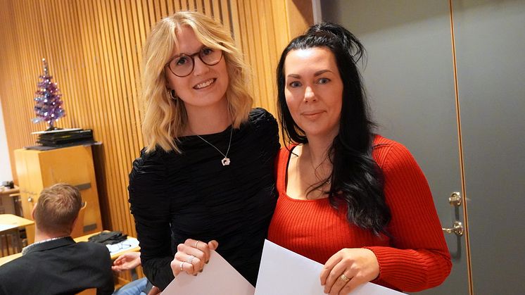 Nyexaminerade Desiré Nilsson och Sara Wånggren med sina examensbevis i hand.